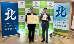 感謝状を持つ竹村社長と、目録を持つ鈴木知事