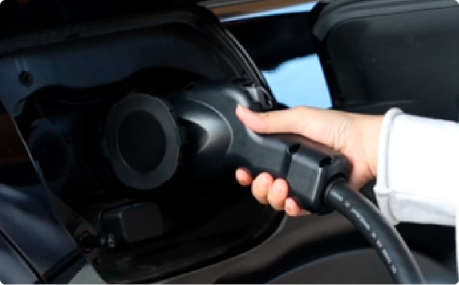 電気自動車（EV）の給電ポートに充電コネクタを差し込む手元のアップのイメージ画像