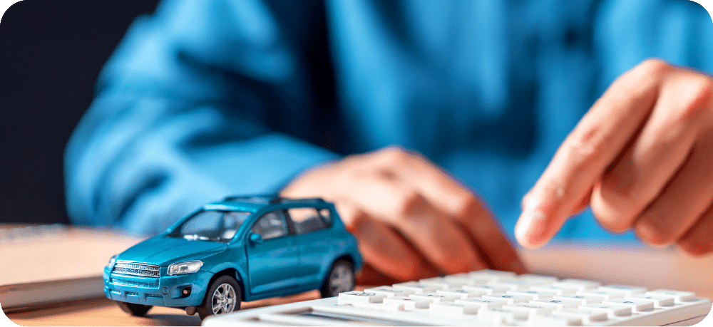 ミニカーを前に電卓で計算をするイメージ