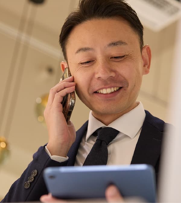 タブレットを確認しながら電話をかけるM.F