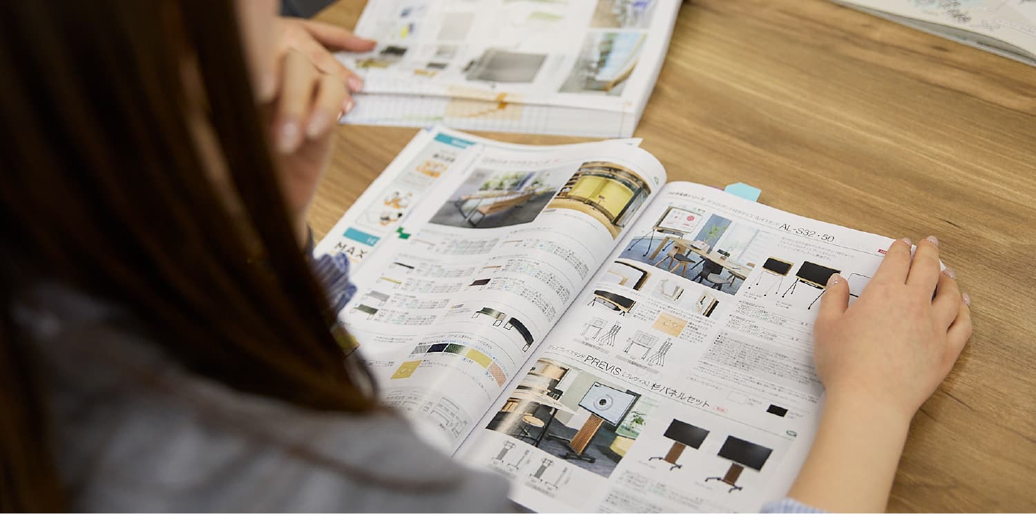 付箋のついたカタログを確認するR.F