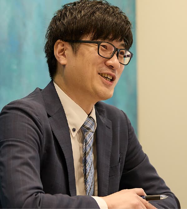 笑顔で打ち合わせを行うT.K